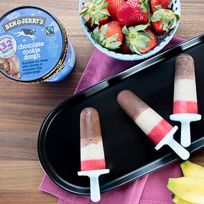 Smoothie Pops on a plate with a pint of Moophoria Chocolate Cookie Dough and a bowl of strawberries